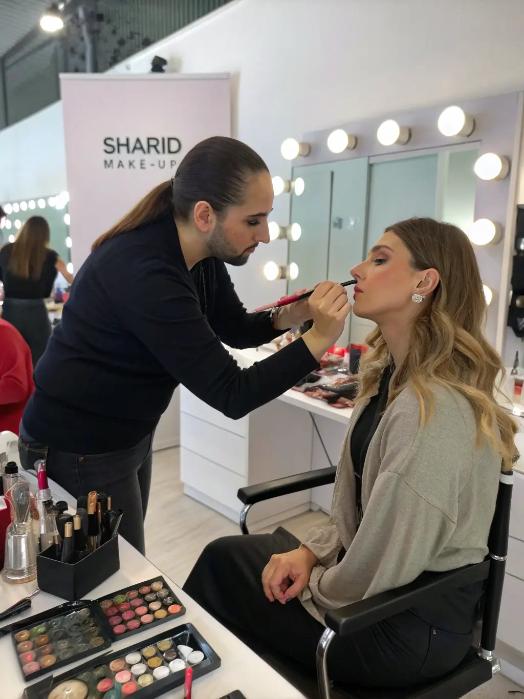 A makeup artist at Name Wellness Studio applying makeup to a client, focusing on enhancing their natural features for a special event. The image should showcase the makeup application service.